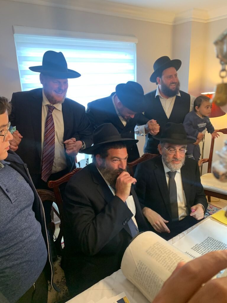 Men learning together over an open sefer