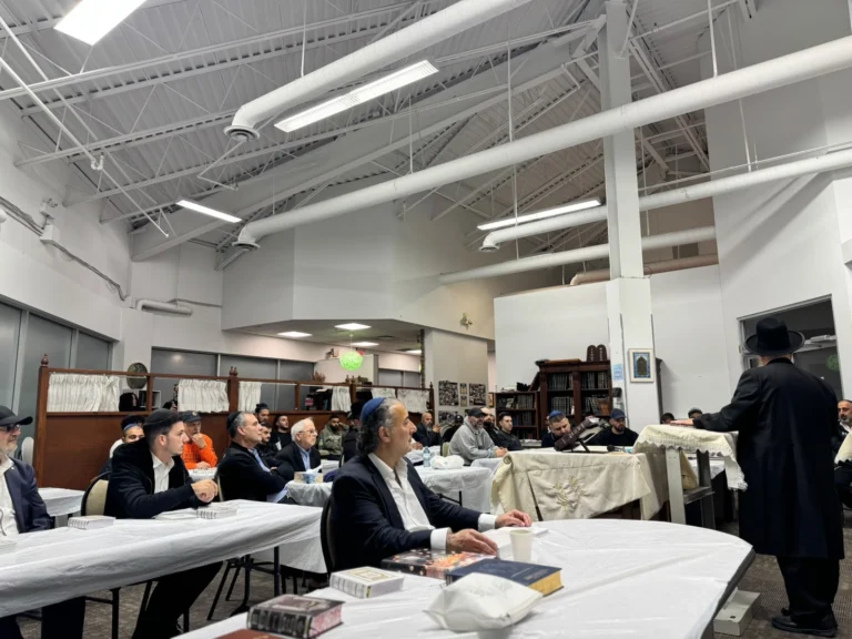 The community listening to a shiur in the main hall
