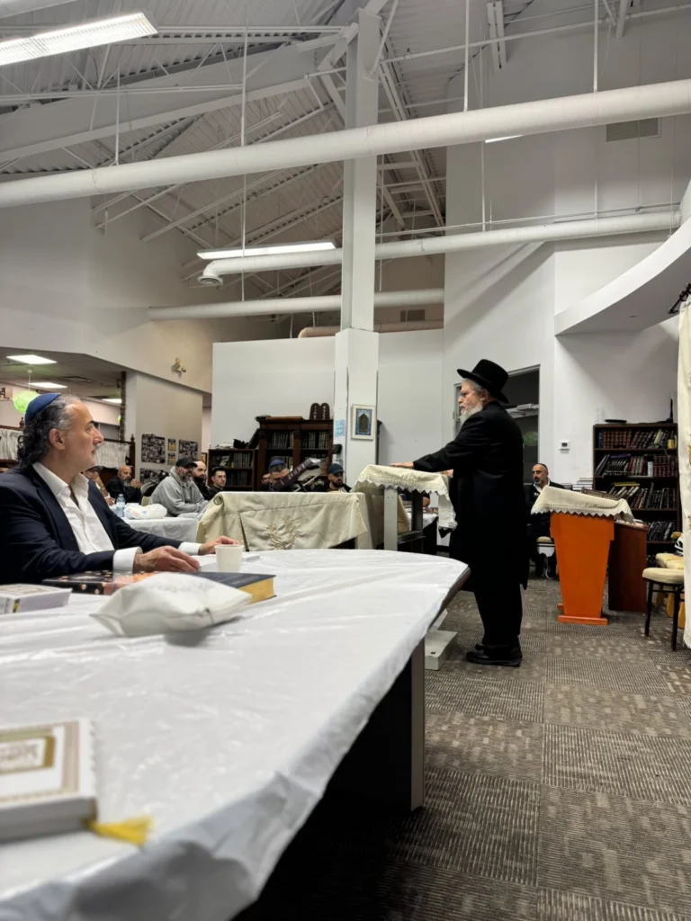 A rabbi giving a shiur from the podium in the Centre's main hall