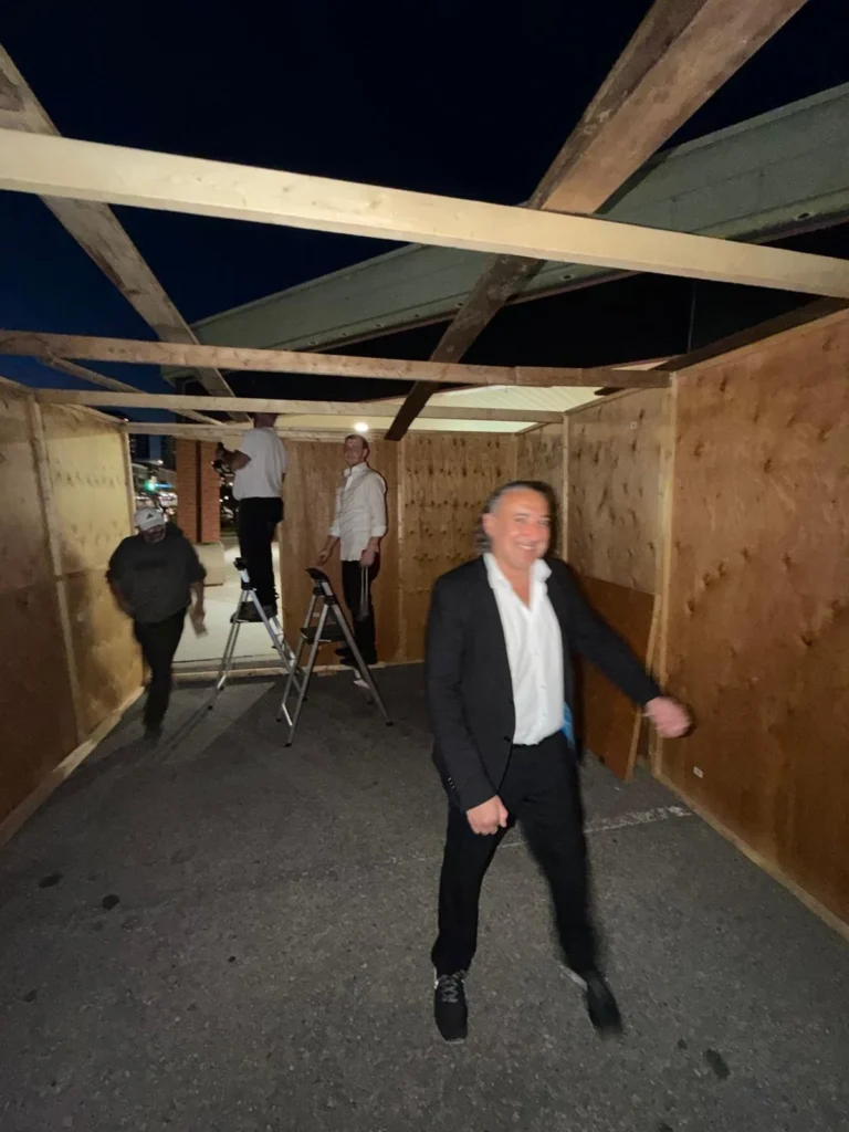 Volunteers building the Centre's sukkah at night
